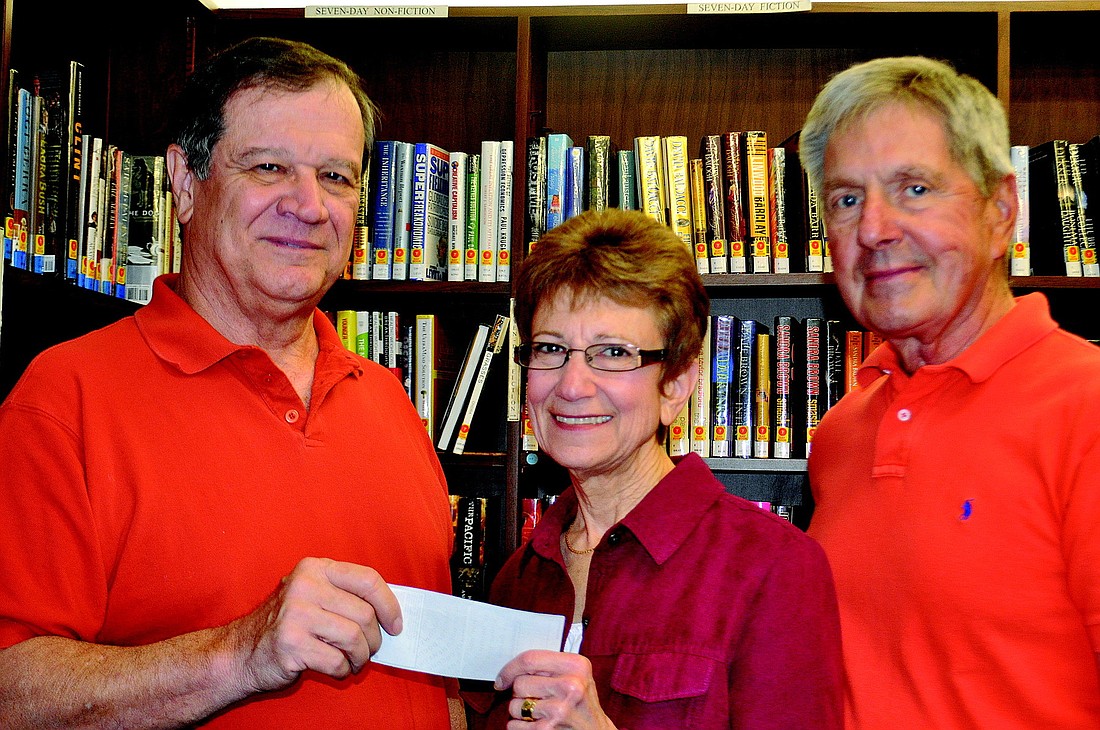 President of Mystery Florida Inc. Terry Griffin presents a check for $2,000 Jan. 4 to Longboat Library President Amy Roth and library volunteer Don Judd.