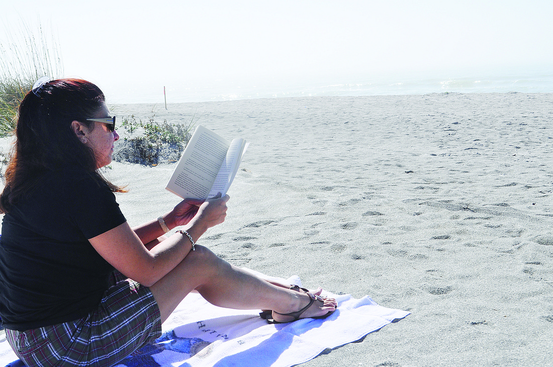 Anna Pedraza, who just moved to the Key from Orlando, reads on the beach Tuesday afternoon, which was one of the warmer days in the last week.