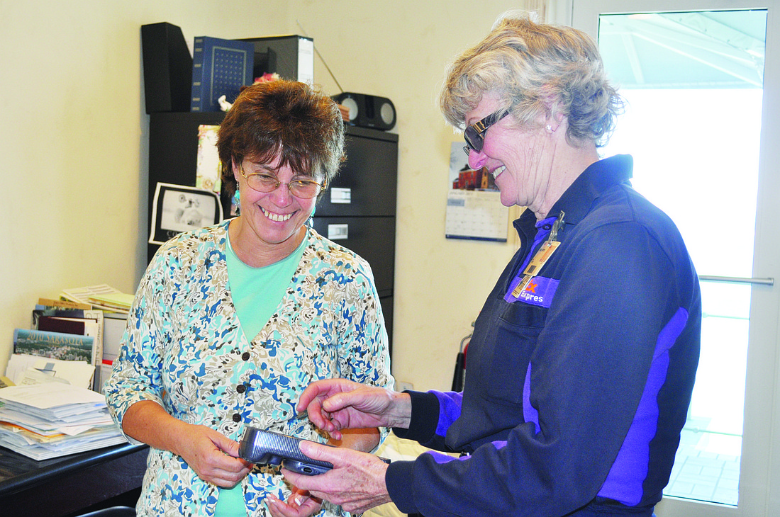 Sue Spry, of Spryco Management, on Longboat Key, receives a package from 30-year FedEx driver Leola "Lee" Meyer.