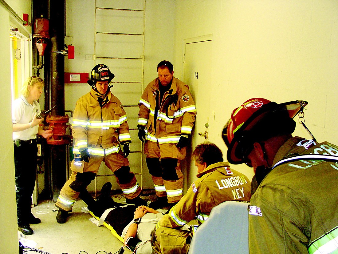Deputy Chief Sandi Drake, left, leads her team of firefighters in conducting a simulated response to a person who fell off a rood.