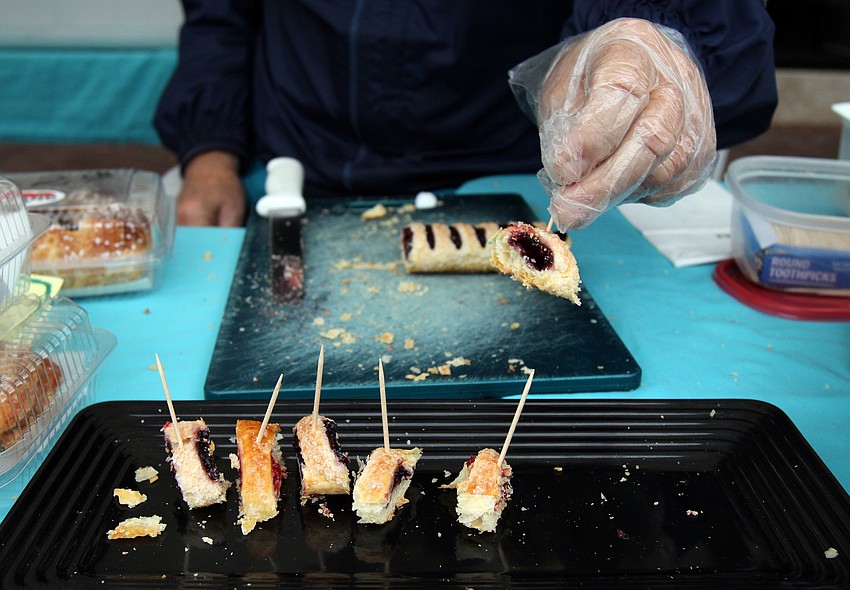 Bill Wing puts out samples of baked goods made by Strudel's Bakery stand on Saturday, Jan. 22  at the farmers market.