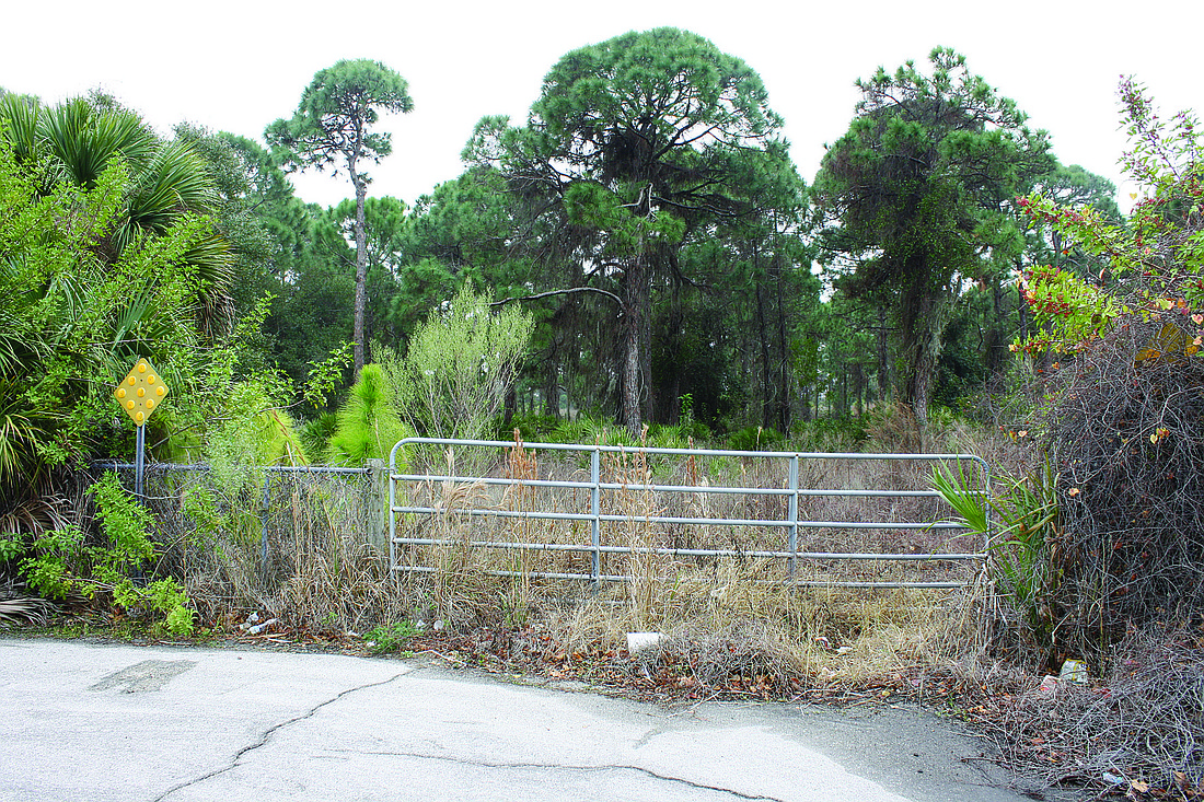 The wooded property beyond this gate off Central Sarasota Parkway will be home to a new Lowe's store, which could open next January.