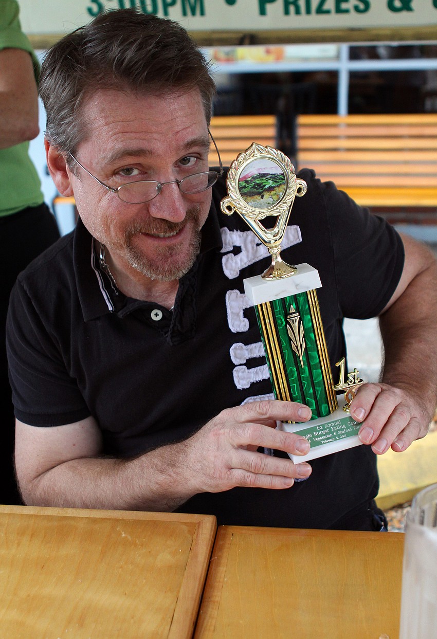 Dr. Patrick Dower shows off the trophy he got along with a dinner for two at Veg during Veg's First Annual Veggie Burger Eating Contest on Saturday, Feb. 5 outside of Veg.