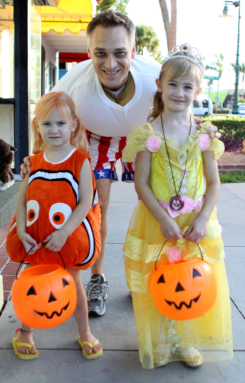 Lauren and Anna pose with their dad, Andy, as they went trick-or-treating on St. Armand's.