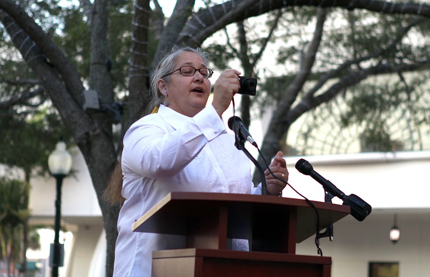 Virginia Hoffman, the Volunteer Public Art Coordinator, takes a photo of the crowd for â€œthe Facebook pageâ€ prior to speaking at the Intersections Kickoff Celebration on Thursday.