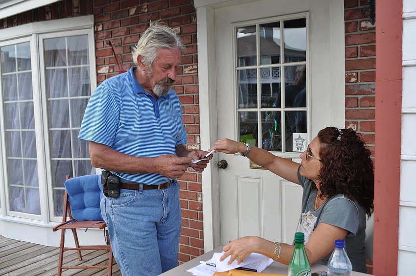 Gerd Kaiser purchases a silent auction raffle ticket from Merryl Koven.