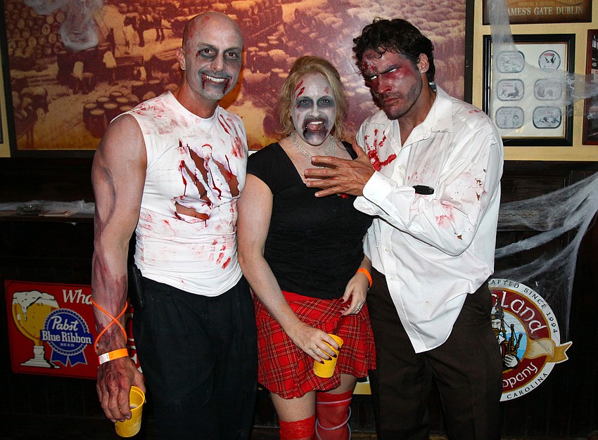 Joe Thomas, Aleshia Meranda and Eric Molina pose together as they celebrate Thomasâ€™ bachelor party at the Sarasota Zombie Pub Crawl.
