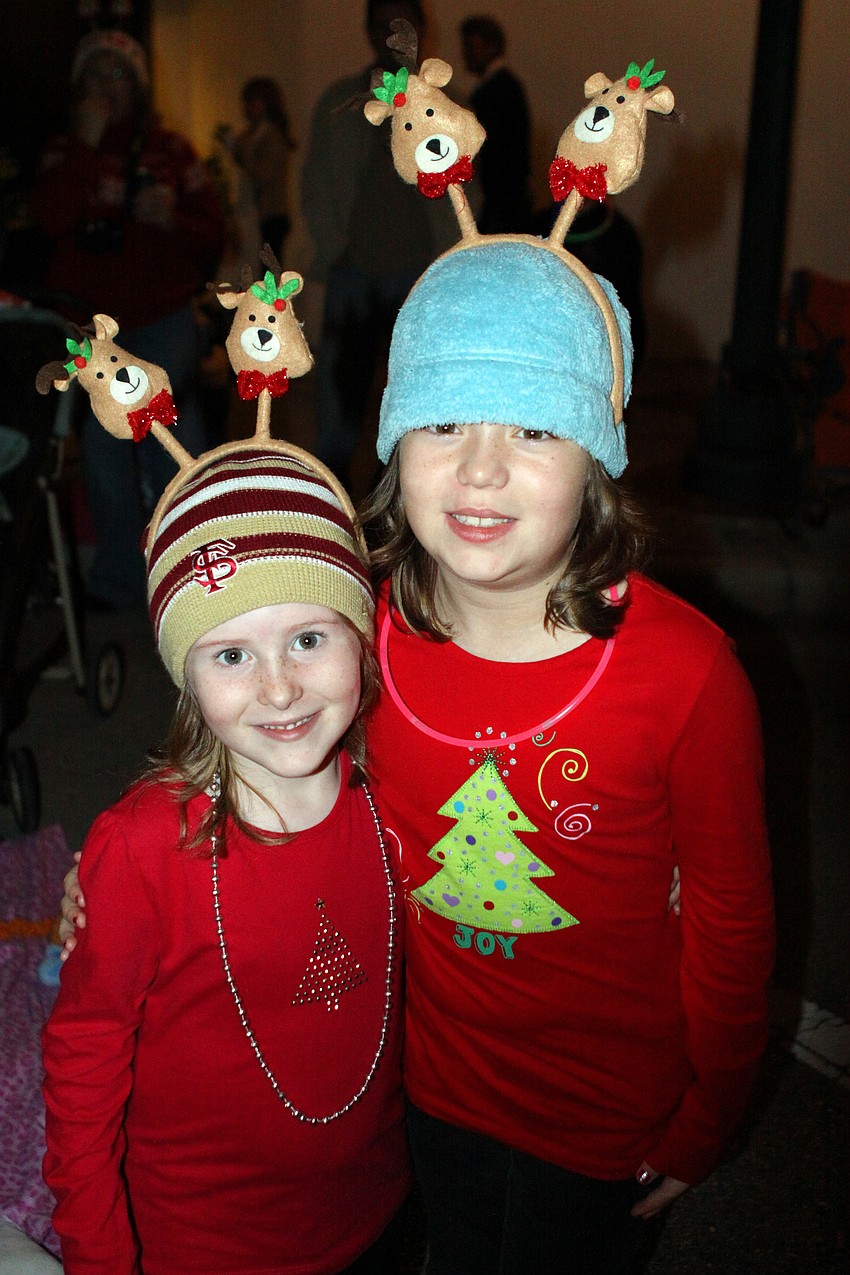 Faith and Desi Martin wear fun reindeer headbands and holiday shirts as they watch the parade.