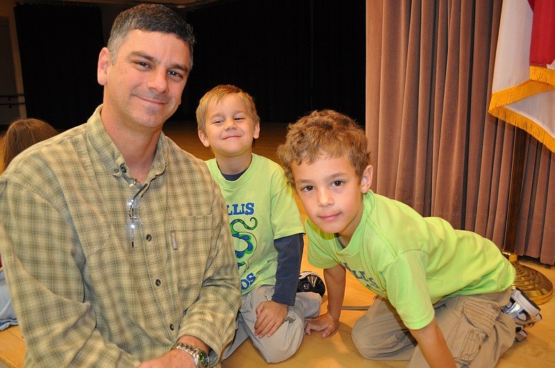 Derek Pollock and his sons Holden and Tanner enjoyed their chocolate glazed doughnuts from a seat on the stage area.