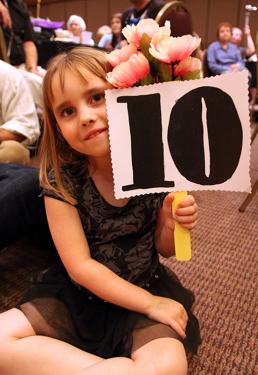Lucy Valentine Thomas, 5, holds up the flowers she got for performing along with the 