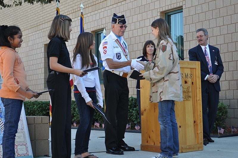 Danielle Rouf, right, accepts her first-place award in the veterans essay contest.