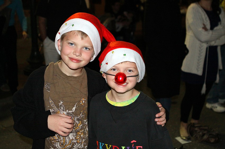 Elgin and Devin Lamperski enjoy watching the parade and wearing some Santa hats and a Rudolph nose.