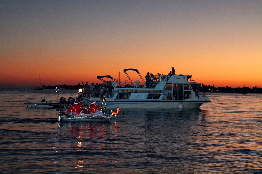 A holiday scene floats across the water on a dinghy that was in the dinghy parade on Saturday, Dec. 11.
