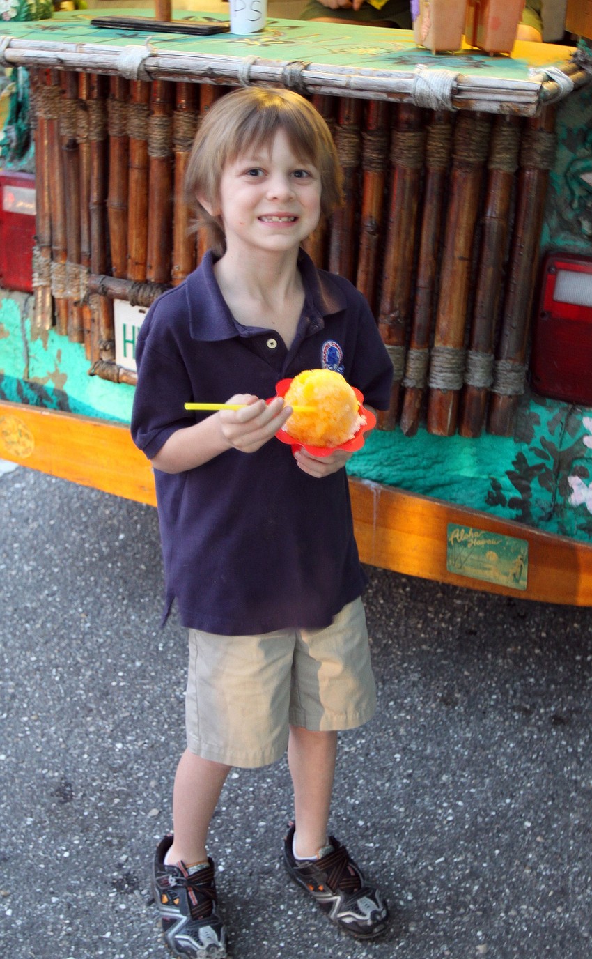 Ethan Swier, 7, enjoys his mango and orange Hawaiian shaved ice on Thursday, March 3 during Rosemary District's Rosemary Rising.