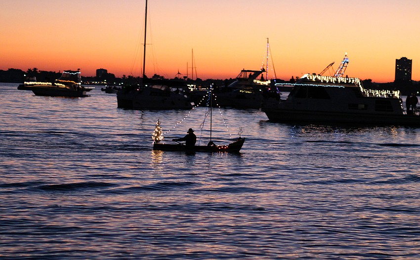 A rowboat makes its way around Bayfront Park during the dinghy parade prior to the holiday boat parade on Saturday, Dec. 11.