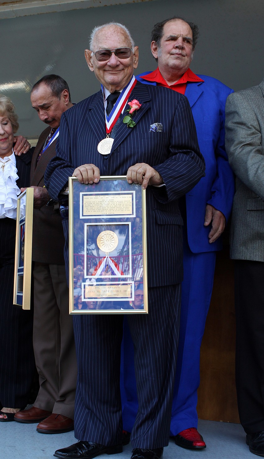 Ward Hall holds his framed award out for the crowd to see. Unfortunately he was unaware that he was holding it up side down until someone jokingly corrected him.