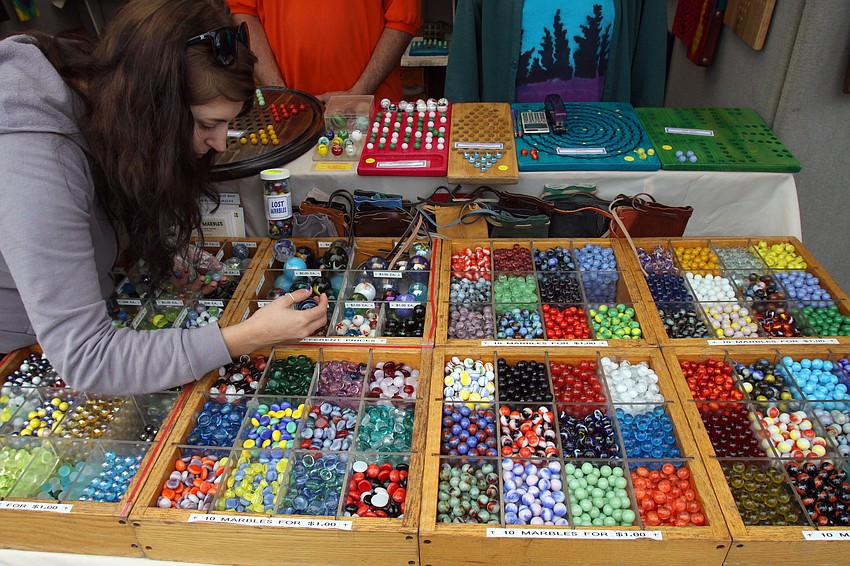 Jess Bolger searches for the perfect marbles to but from The Marble Guy at the 17th annual Siesta Key Craft Festival, Saturday, Feb. 5, in Siesta Key Village.