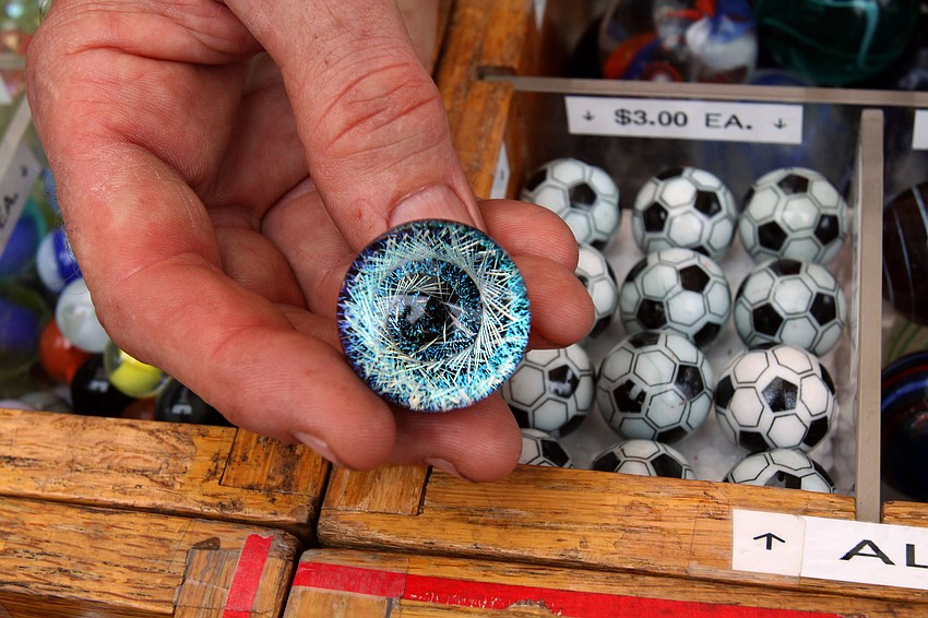 Jack Hahn, the Marble Man, shows off one of his more elite marbles at the 17th annual Siesta Key Craft Festival Saturday, Feb. 5, in Siesta Key Village.