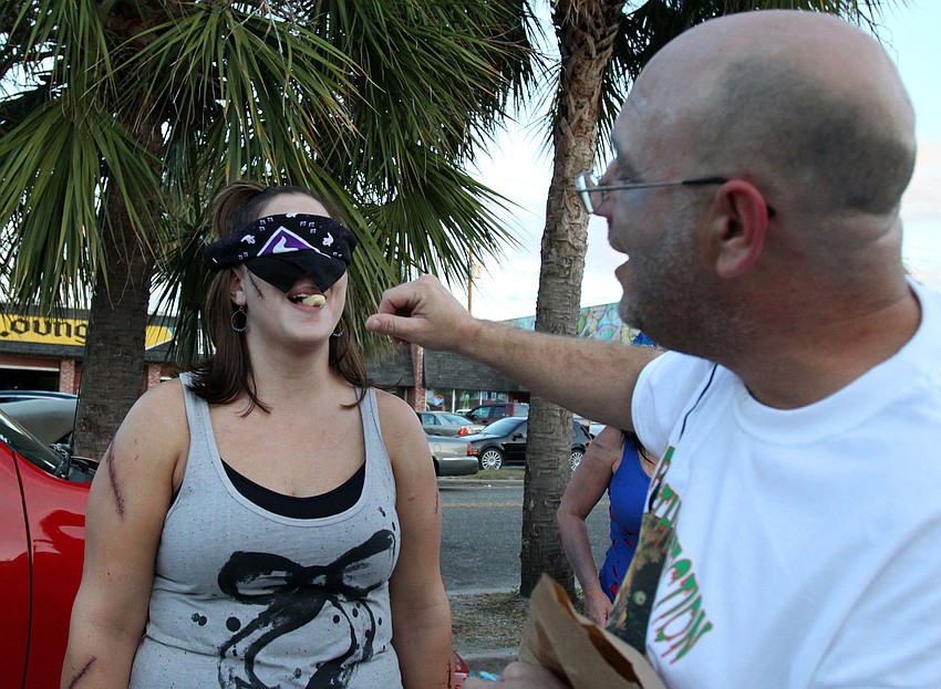 Lisa Longtin tries to guess what candy John Eagen gives her to eat at the Sarasota Zombie Pub Crawl.