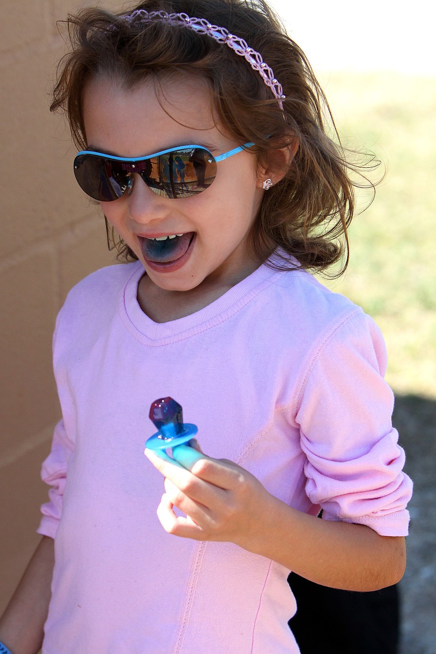 Alexa Ziff, 7, enjoys her ring pop and turing her tongue blue on Saturday, Feb. 19 at Twin Lakes Park during Central Sarasota Little League Opening Day. Ziff also likes, 