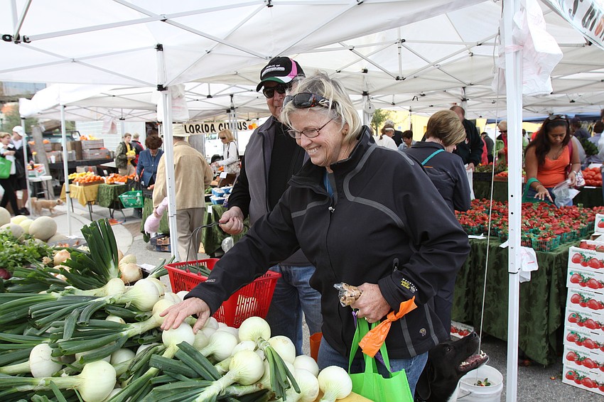 John and Rita Steele visit Brown's Grove's stand with their dog, Bill, on Saturday Jan. 22 at the farmers market.