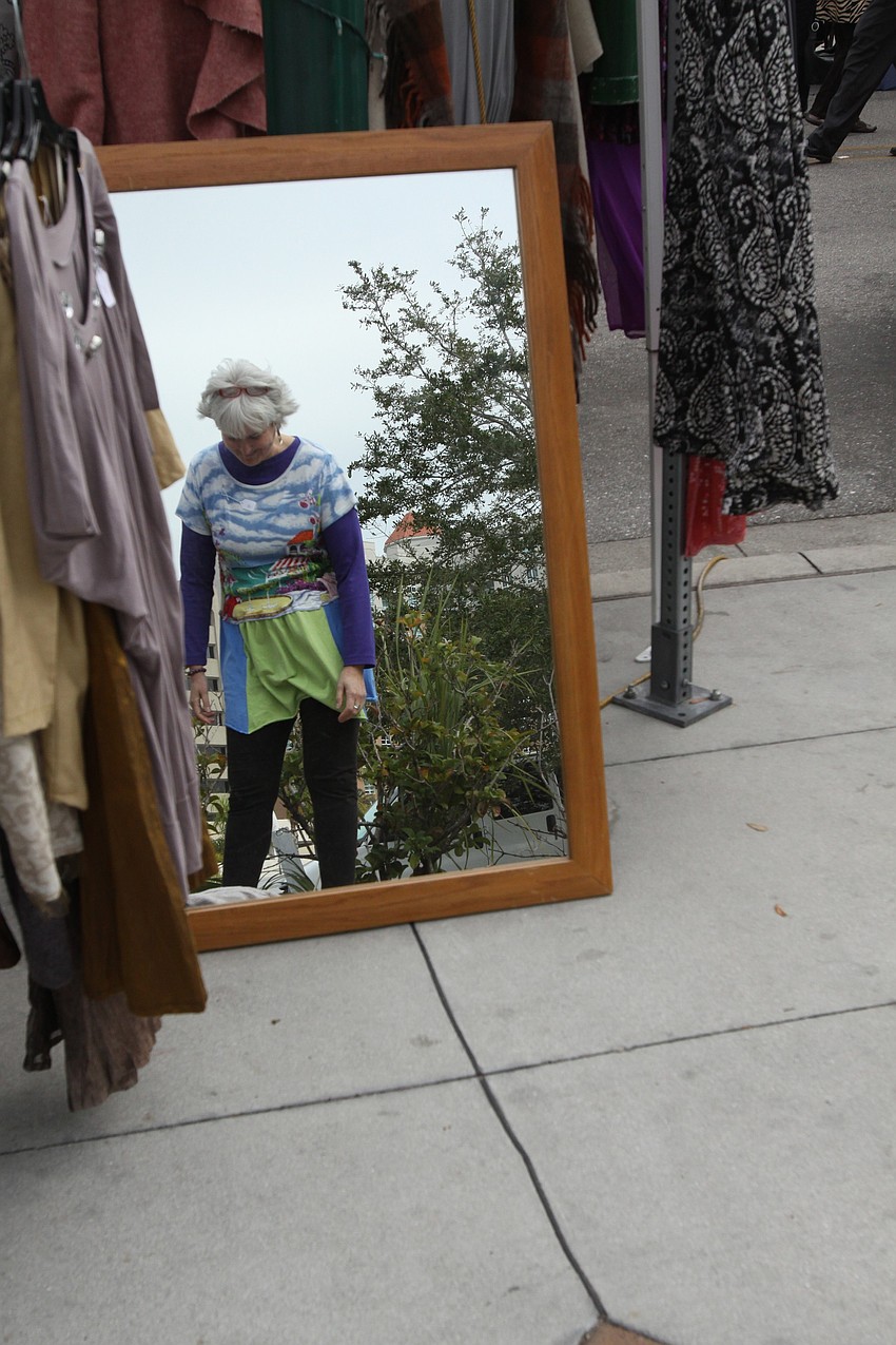 Raven Skye tries on a dress made by Dee Dee & Delight's Eco-Friendly Clothing on Saturday, Jan. 22 at the farmer's market.