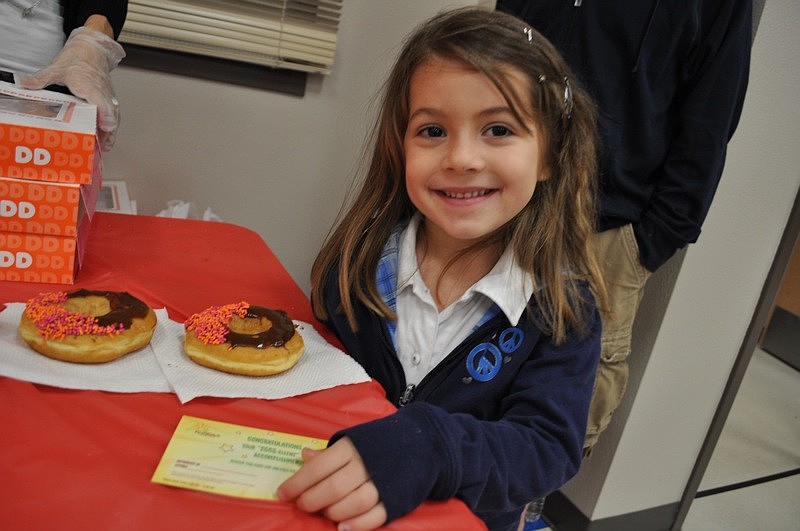 Kate Tuchman, 5, helped her parents pass out doughnuts.