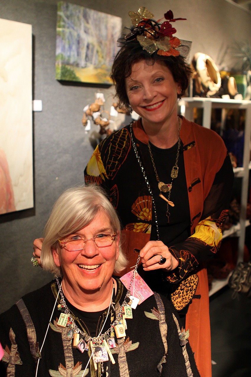 Mimi May puts one of her necklaces onto Carole Reiss who bought the necklace on Thursday, Feb. 10 at the Fabulous Arts Boutique.