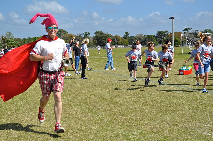 Chris Cahill pumps up the excitement by keeping pace with fourth and fifth graders during their first lap.