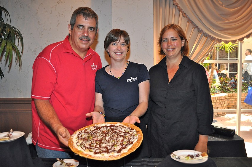 Mark and Molly Lawley and Michelle Graber hold the first chocolate pizza by Evie's.