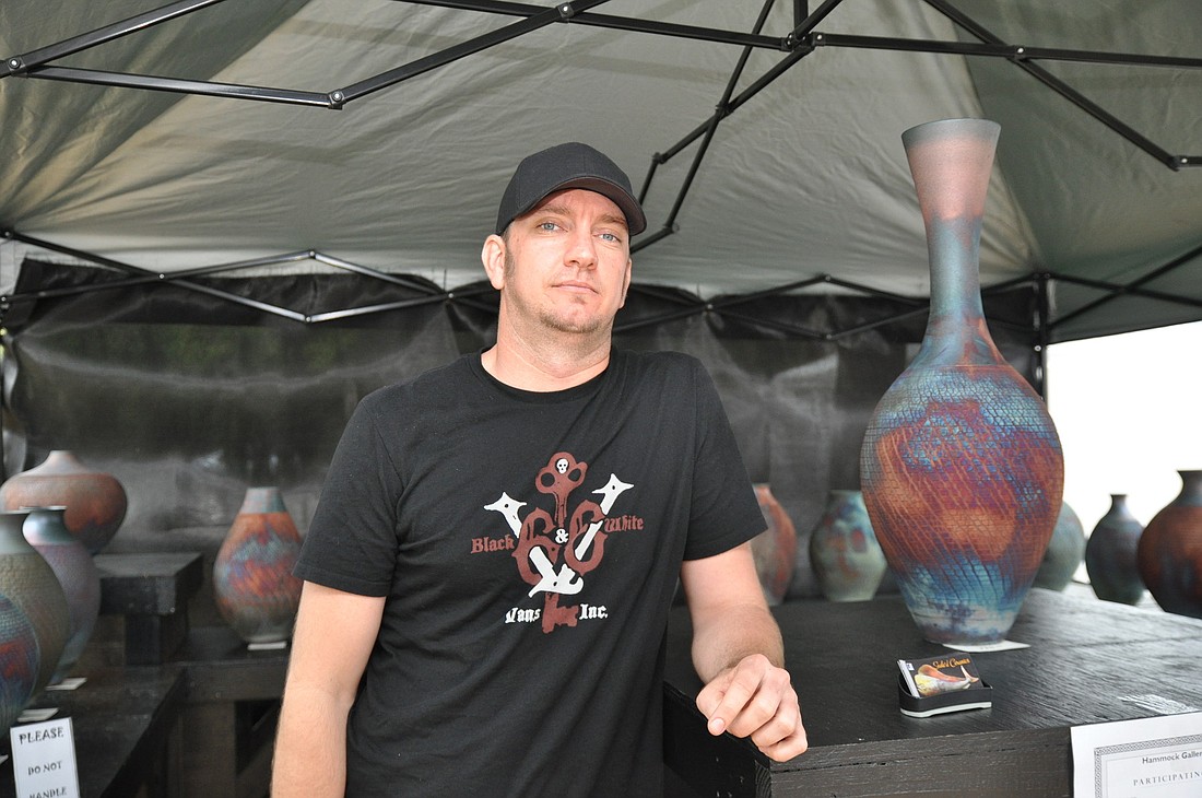 Johnny Seale stands with his is raku ceramic pots. The Palm Coast artist just recently started showing his work.