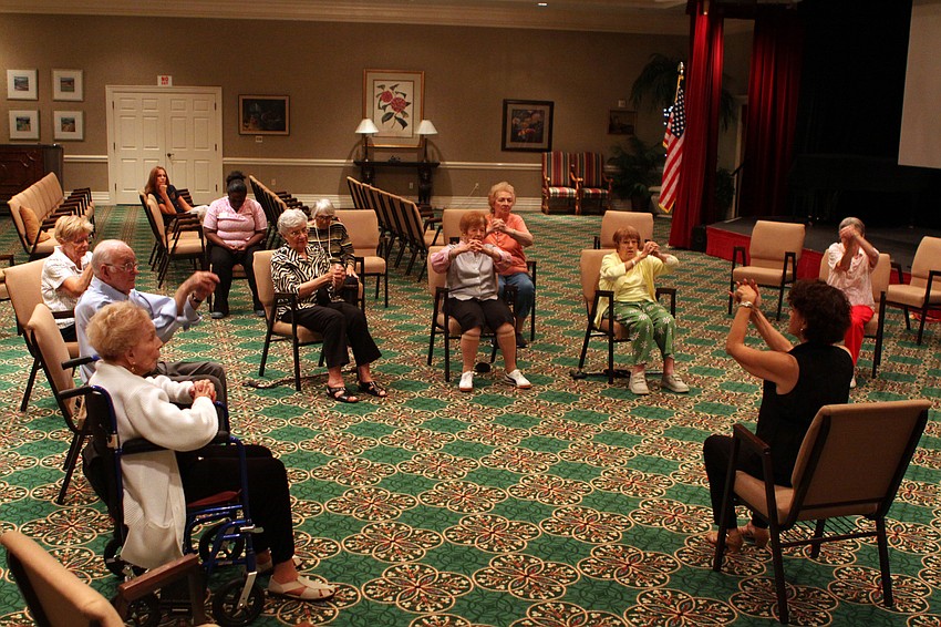 The class move their clasped hands in figure-eights.