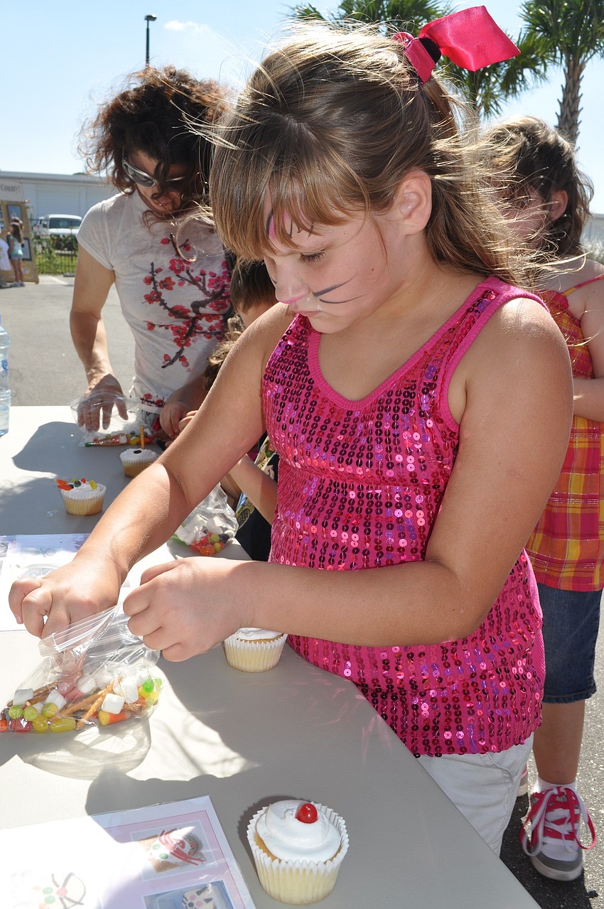 Lauren Hetzer, age 7, decorates a cupcake.