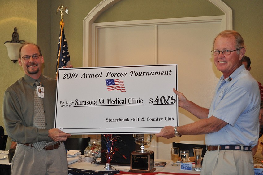 Event organizer Mike Charles presents a check for $4,025 to Steve Totterdale from the Department of Veteran Affairs.