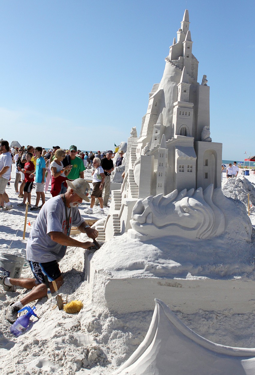 Ky Terrell works on the sand sculpture he and Andy Hancock created entitled 