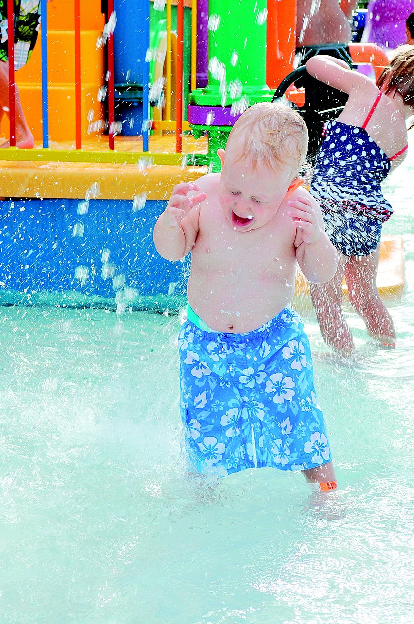 Bryce Caffrey giggles while underneath a waterfall in August at Potter Park YMCA's 