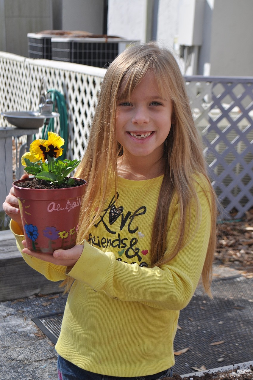 Abigail Wolfer shows off her decorated flower pot.