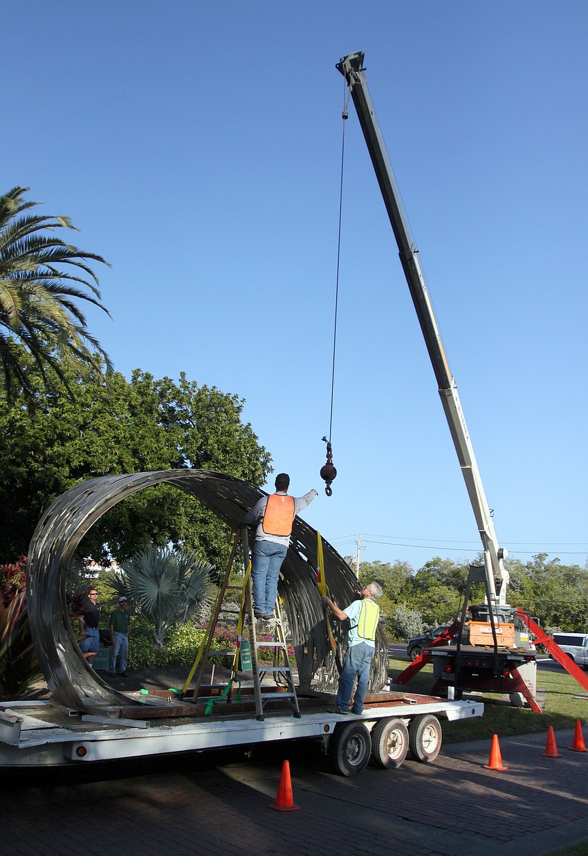 Crockett Young reaches out toward the crane as Thom Berry advises.