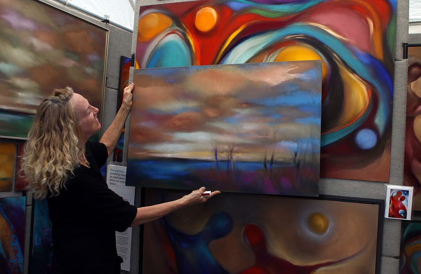Diane French shows the different sizes of two of her paintings to a potential buyer on Saturday, Jan. 29 at St. Armand's Art Fair.