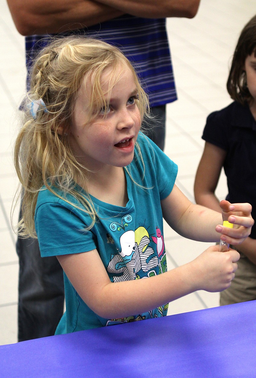 Abigail Koester shakes a test tube that eventually showed her DNA with tiny strands of bubbles on Friday, Feb. 25 at Southside Elementary's Science Night.