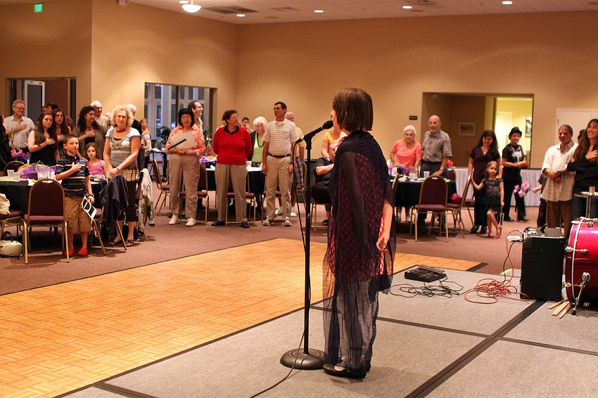 April Guttman, 7, sings the National Anthem on Feb. 26 at Temple Sinai's 2nd Annual 