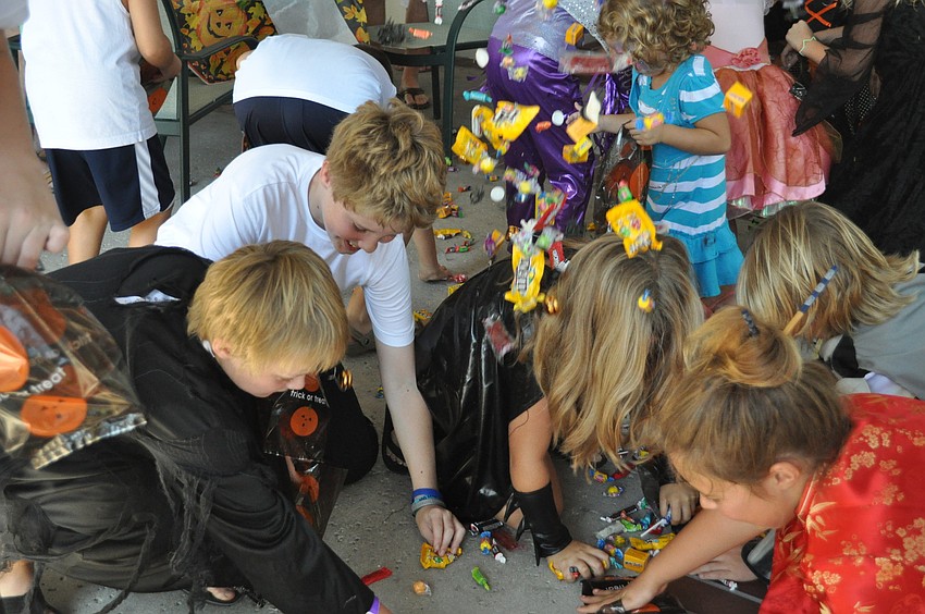 The kids scramble for pinata candy.