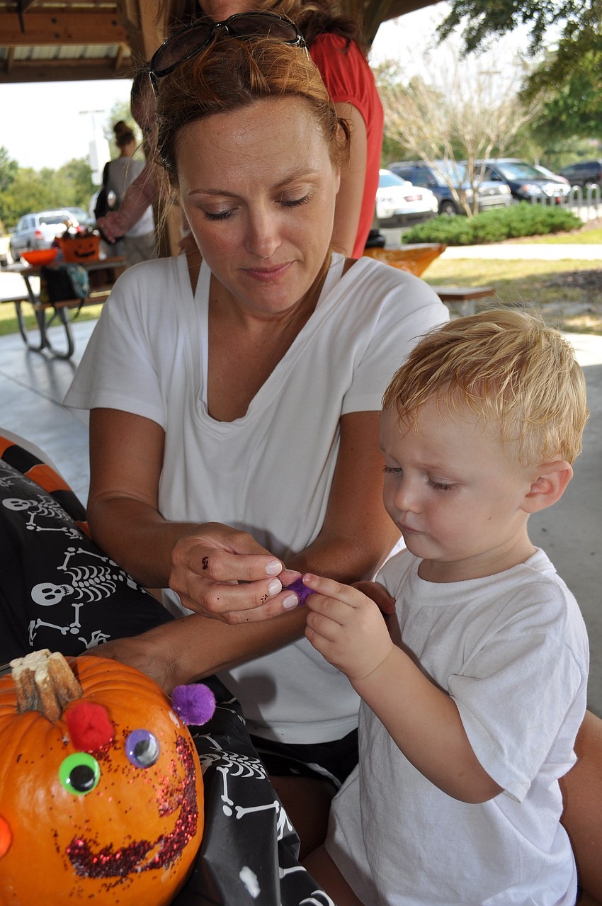 Angelene Brawner helped her son Logan decorate a pumpkin.