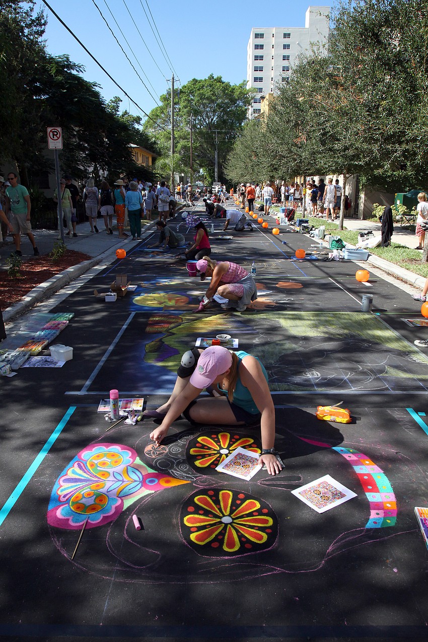 Chalk artists working on their pieces on a side street by Burns Court.