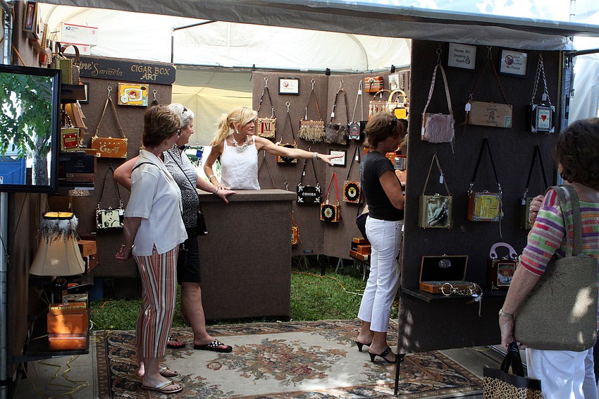 People look inside the tent for Elaine's Sarasota Cigar Box Art at the St. Armands Art Festival.