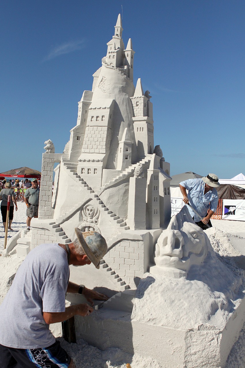 Ky Terrell and Andy Hancock work away at their sand sculpture on Saturday afternoon.