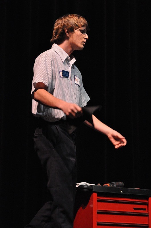 Shop manager Shane Lynch, played by Kyle James, chastises his employees for their laziness.