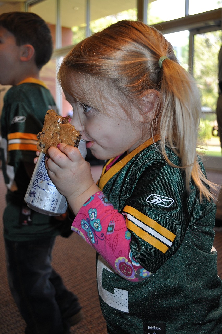 2-year-old Ava Lenerz washes down her cookie with a sip of soda.