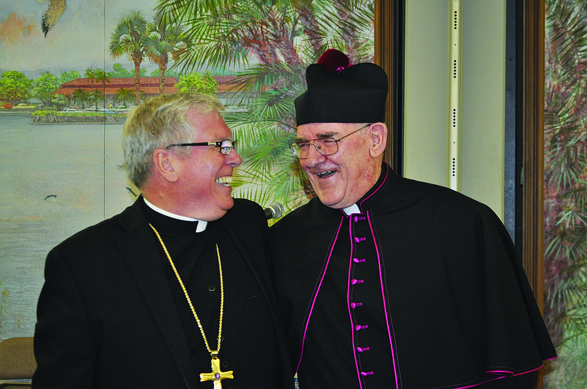 Bishop Frank Dewane, from the Diocese of Venice, laughs with Msgr. Gerry Finegan in September at the investiture ceremony for Finegan at St. Mary, Star of the Sea, Catholic Church.