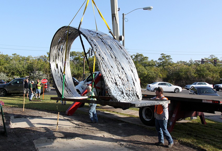 Thom Berry and Crockett Young try to maneuver the Wave 2 Me Sculpture on Wednesday, Jan. 19 in front of Longboat Key Club & Resort Islandside.